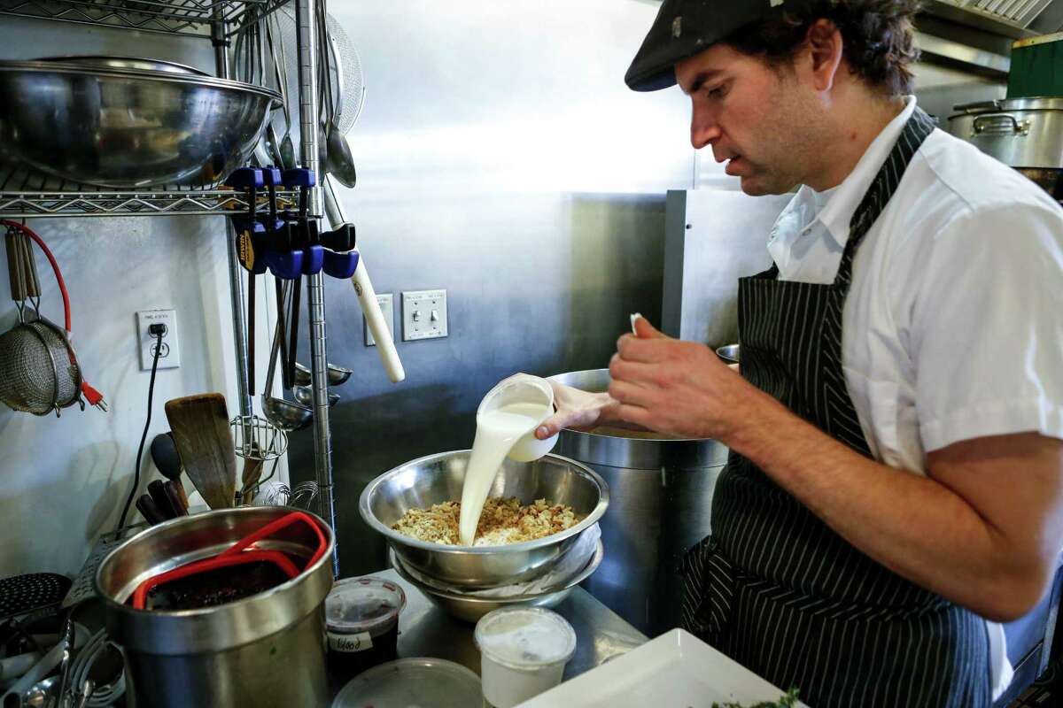 Nick Bonino, value-added products manager at the Local Butcher Shop in Berkeley, mixes ingredients to make blood sausage.