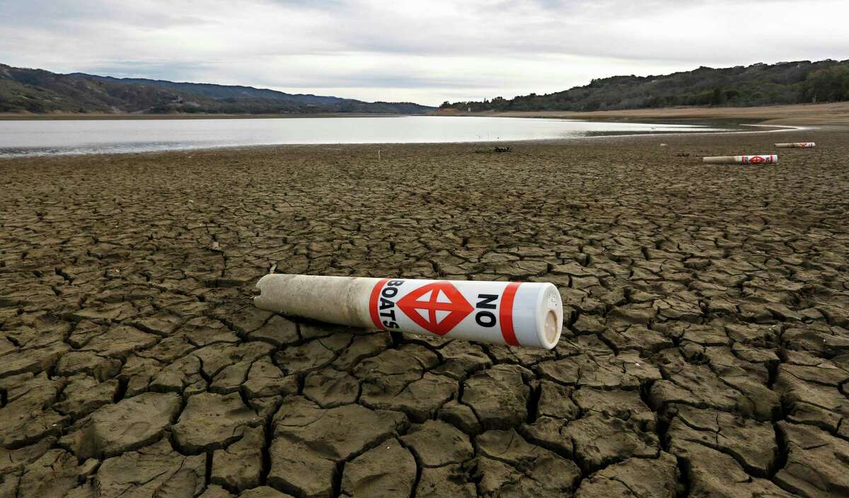 FILE - In this Feb. 4 2014 file photo, a warning buoy sits on the dry, cracked bed of Lake Mendocino near Ukiah, Calif. As bad as the drought in California and the Southwest was last year and in the Midwest a couple years ago, scientists say far worse historic decades-long dry spells are coming. “Unprecedented drought conditions” _ the worst in more than 1,000 years _ are likely to come to the Southwest and Central Plains near the end of this century and stick around because of global warming, according to a new study in the journal Science Thursday.