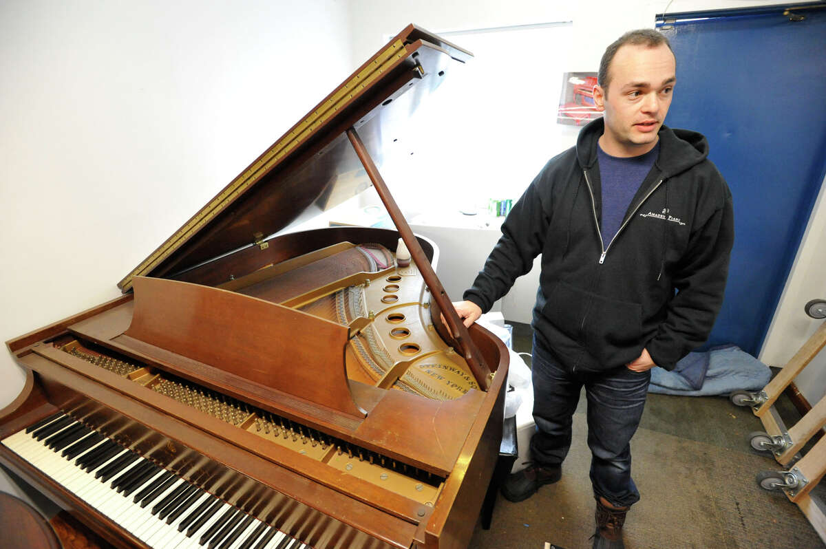 Yury Feygin, owner of Amadeus Piano, shows off a Steinway piano on display at his business in Stamford, Conn., on Wednesday, Feb. 4, 2015. The piano company mainly deals with tuning, repairs, moving, storage, restoration and antique piano sales with locations in Westport and Long Island, NY.