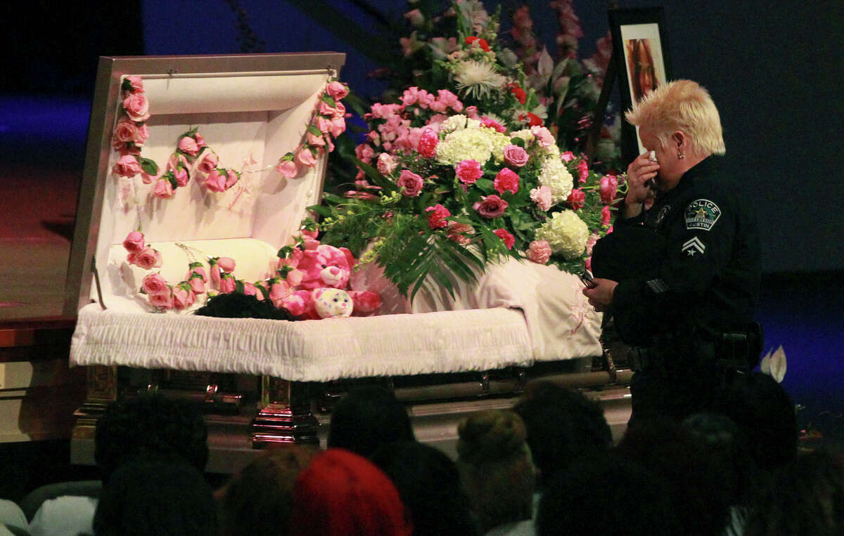 A police officer pays respects Friday February 13, 2015 at the casket of Samantha Elizabeth Dean during her funeral at Community Bible Church in San Antonio. Dean, who worked for the Kyle, Texas Police Department as the coordinator for its Victims Service Unit, was found dead on February 4 lying next to a car behind a building near Bastrop, Texas. Dean, who was pregnant, was shot in the head.