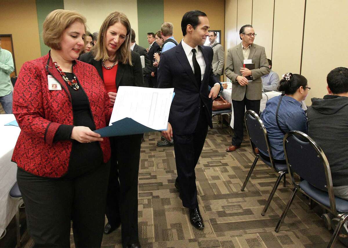 CentroMed's Ana Maria Garza Cortez (left) provides a tour for Secretary of Health and Human Services Sylvia Burwell and Secretary of Housing and Urban Development Julián Castro as people enroll in health insurance plans Friday at CentroMed.