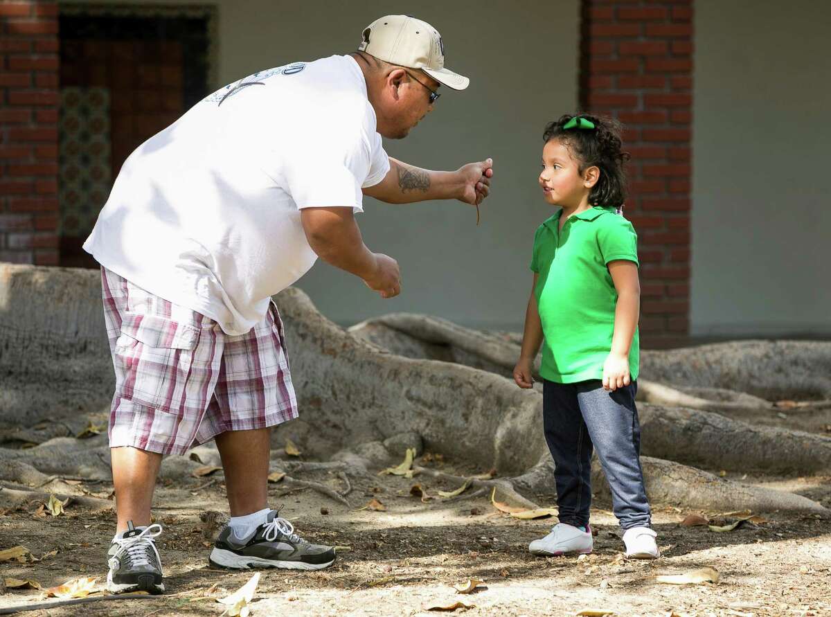 In this photo taken Feb. 11, 2015, Santos Lopez crushes a tree leaf for his daughter, Angelica Lopez, 3, so she can experience the sound. Angelica was born deaf and received an auditory brainstem implant to allow her to hear some sounds. She is part of a research study of the device in youngsters at the University of Southern California. U.S. researchers are implanting a device on the brain stems of a small number of deaf children to see if it will help them learn to hear. The studies are aimed at children who don?’t have working hearing nerves and thus don?’t qualify for a more common technology, cochlear implants. The implants stimulate brain cells that those nerves normally target. (AP Photo/Damian Dovarganes)