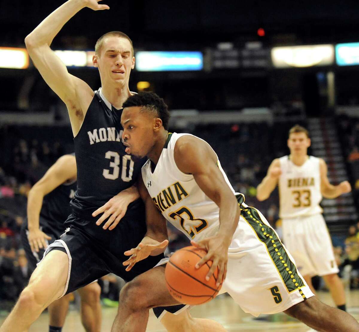 Siena's Maurice White, center, drives past Monmouth's Collin Stewart during their basketball game on Saturday, Feb. 14, 2015, at Times Union Center in Albany, N.Y. (Cindy Schultz / Times Union)