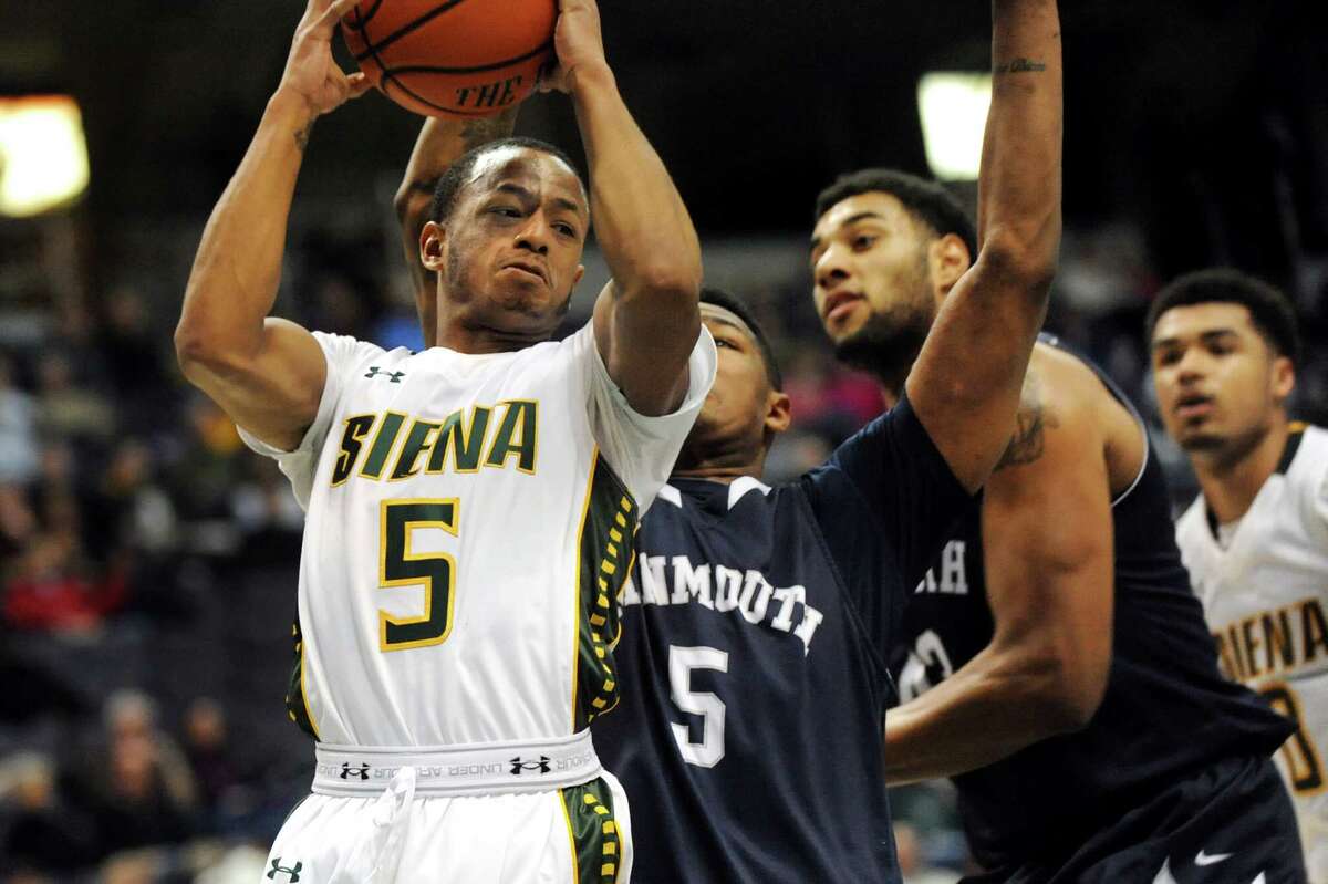Siena's Evan Hymes, left, looks to pass as Monmouth's Deon Jones defends during their basketball game on Saturday, Feb. 14, 2015, at Times Union Center in Albany, N.Y. (Cindy Schultz / Times Union)