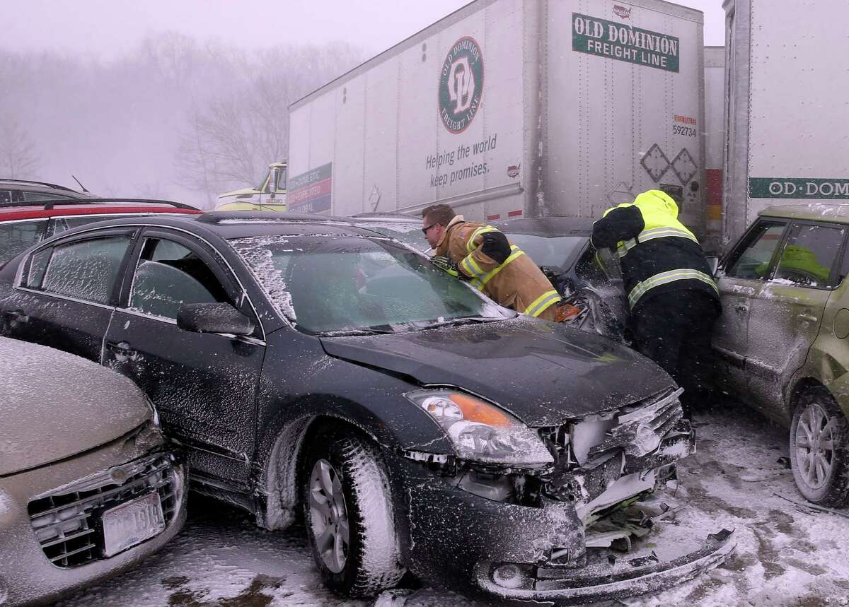 First responders check on occupants of a multi-vehicle accident in near white out conditions, blocking west bound I-70, Saturday, Feb. 14, 2015 west of Columbus, Ohio. Heavy blowing snow is making travel difficult across Ohio and has caused quite a few accidents on the interstates. (AP Photo/Alex Brandon)
