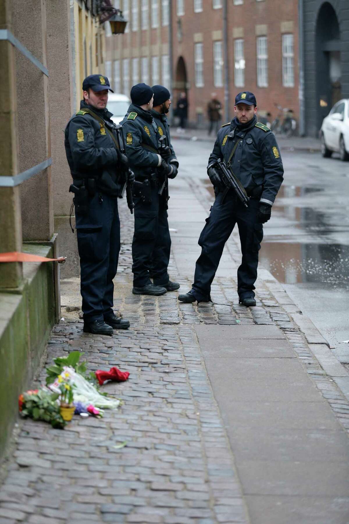 Danish police officers stand outside of a synagogue, Sunday, Feb. 15, 2015, where a gunman opened fire in Copenhagen, Denmark. Danish police shot and killed a man early Sunday suspected of carrying out shooting attacks at a free speech event and then at a Copenhagen synagogue, killing two men, including a member of Denmark's Jewish community. Five police officers were also wounded in the attacks. (AP Photo/Niels Hougaard, POLFOTO) DENMARK OUT ORG XMIT: COP807