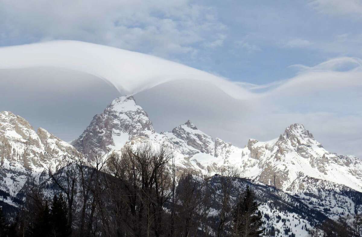 This photo taken Thursday, Feb. 12, 2015, and provided by the Grand Teton National Park, shows an unusual cloud formation across the summit of the Grand Teton in this view from the park's headquarters campus at Moose, Wyo.