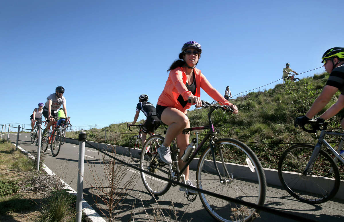 Bicyclists ride near the Golden Gate Bridge. A bill has been introduced in the state Senate to make helmets mandatory for all bicycle riders, requiring adults to wear them, not just minors.