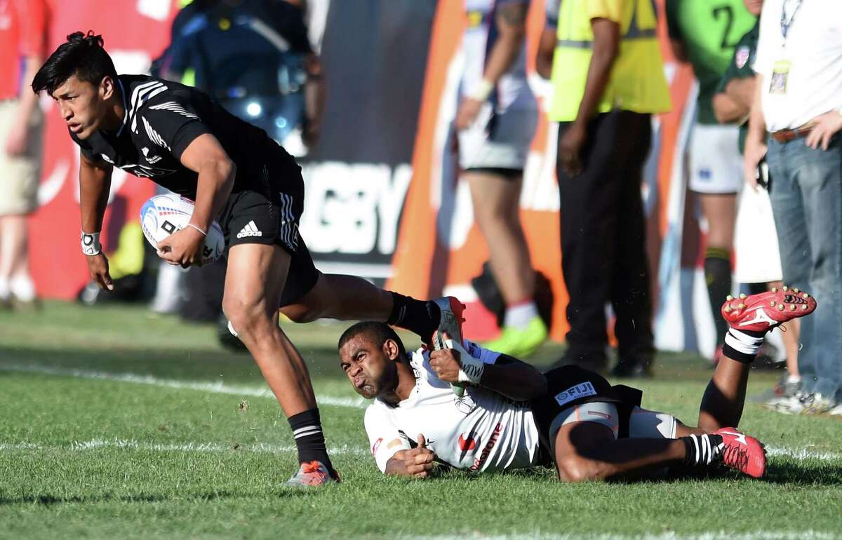Rieko Ioane #11 of New Zealand is tripped up by Vatemo Ravouvou #12 of Fiji in the Cup Final match.