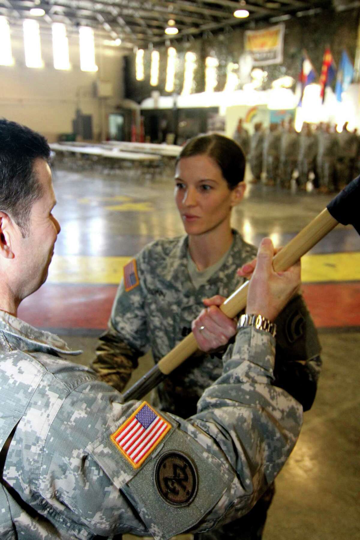 Lt. Col. Christopher Panzer, the battalion commander, passes the guidon to Capt. Amanda Ponn as she assumes command the 42nd Infantry Division Headquarters Support Company, New York Army National Guard.