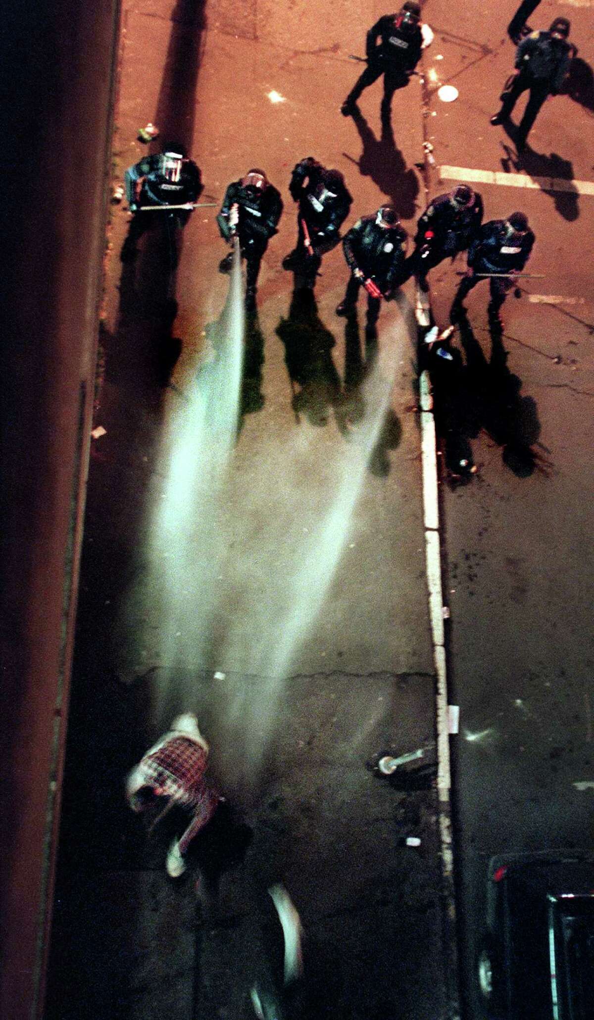 Seattle Police officers gas a man on James street in Seattle while clearing the streets after a Mardi Gras celebration which turned into a protest in Pioneer Square early the morning of Feb. 25, 2001.
