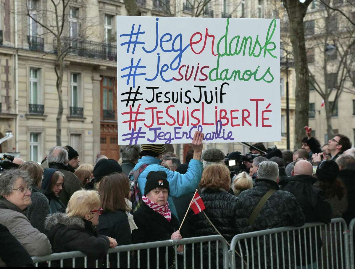 A man holds a placard with the hashtags "I am Danish, I am Jewish, I am Freedom" next to a woman holding a Danish flag outside the Danish Embassy in Paris on February 16, 2015, where France's political leaders attended a commemorative gathering after double shootings that killed two people at a cultural centre and a synagogue in Copenhagen on February 14. The twin attacks on a cultural centre and synagogue in Copenhagen left two people dead and five police officers wounded before the assailant himself was gunned down. AFP PHOTO / JACQUES DEMARTHONJACQUES DEMARTHON/AFP/Getty Images
