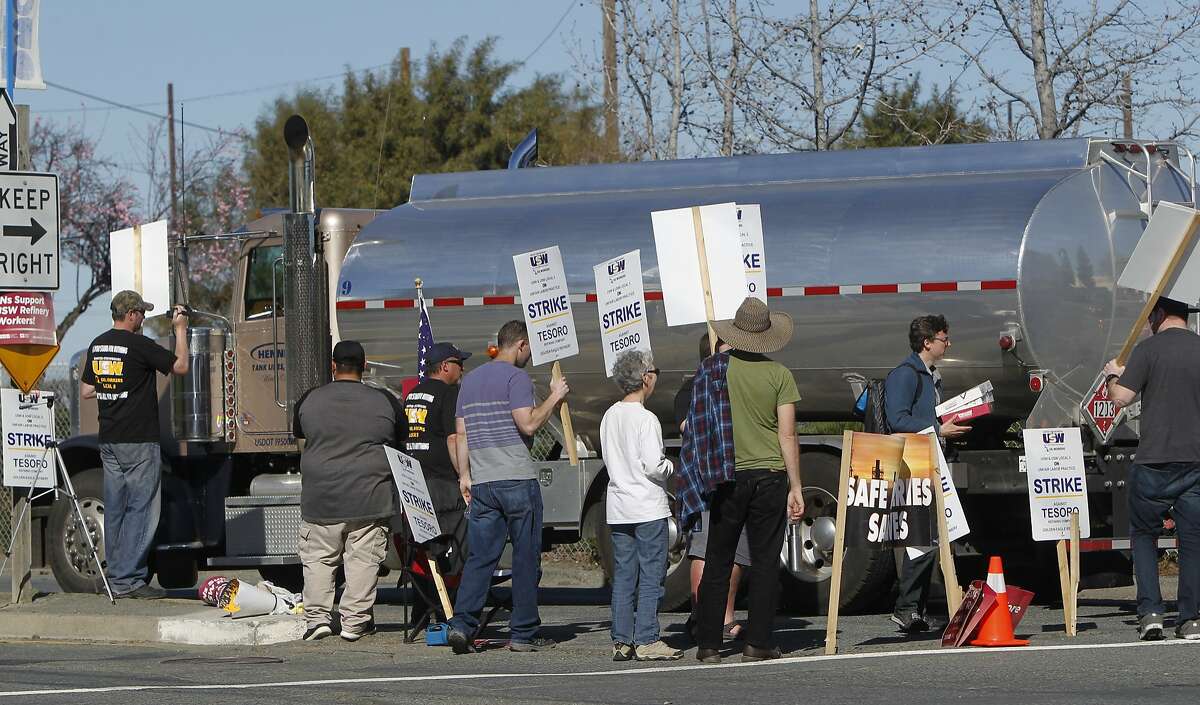 A group of United Steelworkers approach a truck crossing the picket line while protesting outside the Tesoro Golden Eagle Refinery in Martinez, Calif. Saturday, February 14, 2015.