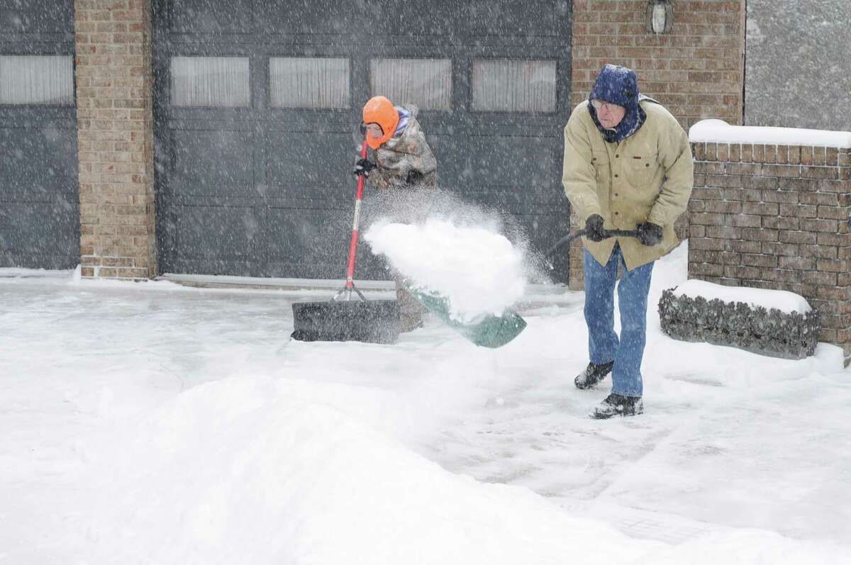 Andrew Kirk and Cameron Gibson shovel snow from Kirk's residence Monday, Feb. 16, 2015 in Cannonsburg, Ky., as snow accumulates during a winter storm. Up to 7 inches of snow were reported in some areas by midmorning Monday amid scenes of cars fishtailing and sliding off highways in Louisville. (AP Photo/The Independent, Kevin Goldy)