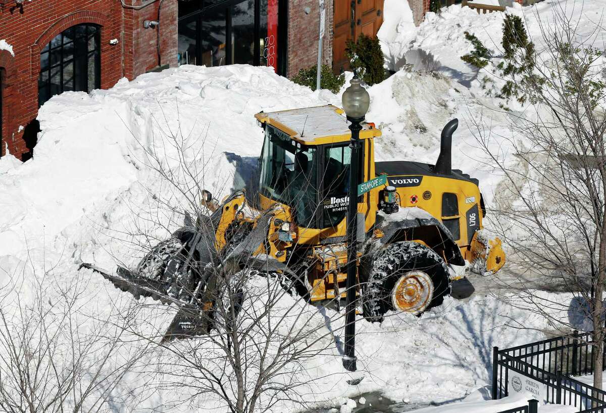 A front-end loader clears snow from the street in Boston, Monday, Feb. 16, 2015. New England remained bitterly cold Monday after the region's fourth winter storm in a month blew through. (AP Photo/Michael Dwyer)