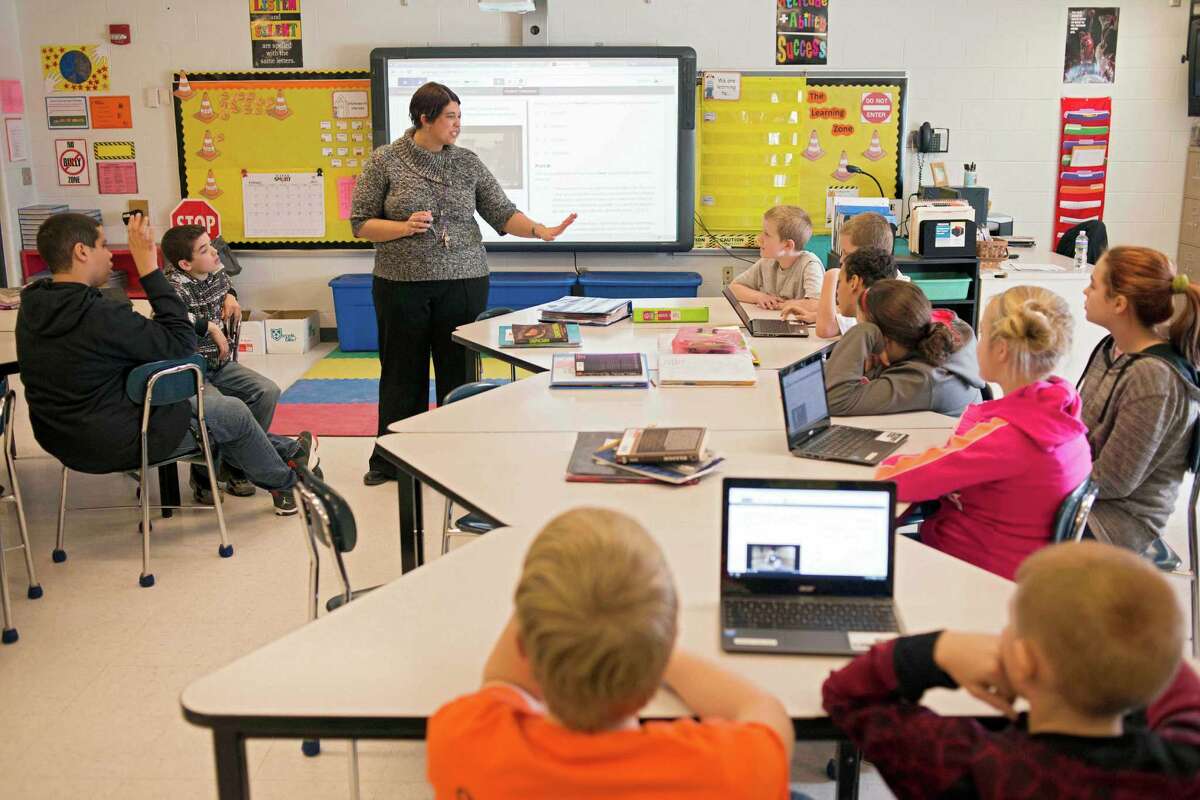 In this photo taken Feb. 12, 2015, sixth grade teacher Carrie Young guides her students through an exercise on their laptops as practice for the the Common Core State Standards Test in her classroom at Morgan Elementary School South in Stockport, Ohio. On Tuesday, Ohio becomes the first state to administer one of two tests in English language arts and math based on the Common Core standards developed by two separate groups of states. By the end of the year, about 12 million children in 28 states and the District of Columbia will take exams that are expected to be harder than traditional spring standardized state tests they replace. In some states, they'll require hours of additional testing time students will have to do more than just fill in the bubble. The goal is to test students on critical thinking skills, requiring them to describe their reasoning and solve problems. (AP Photo/Ty Wright) ORG XMIT: WX205