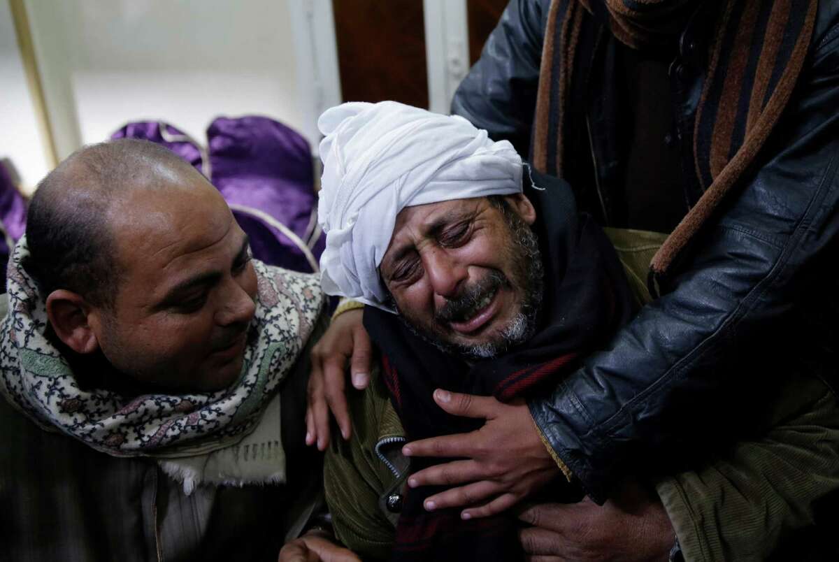 A man is comforted by others as he mourns over Egyptian Coptic Christians who were captured in Libya and killed by militants affiliated with the Islamic State group, outside of the Virgin Mary church in the village of el-Aour, near Minya, 220 kilometers (135 miles) south of Cairo, Egypt, Monday, Feb. 16, 2015. Egyptian warplanes struck Islamic State targets in Libya on Monday in swift retribution for the extremists' beheading of a group of Egyptian Christian hostages on a beach, shown in a grisly online video released hours earlier. (AP Photo/Hassan Ammar) ORG XMIT: HAS110
