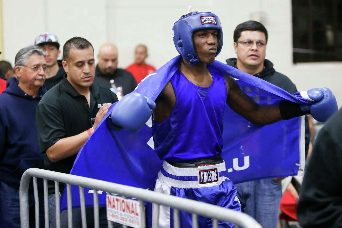 Kamryn Dyungy (right) fighting with the USAF, prepares to enter the ring followed by coaches Bobby De Leon and Osmar Alaniz during opening night of the 2015 San Antonio Regional Golden Gloves boxing tournament at Woodlawn Gym on Monday, Feb. 16, 2015. MARVIN PFEIFFER/ mpfeiffer@express-news.net