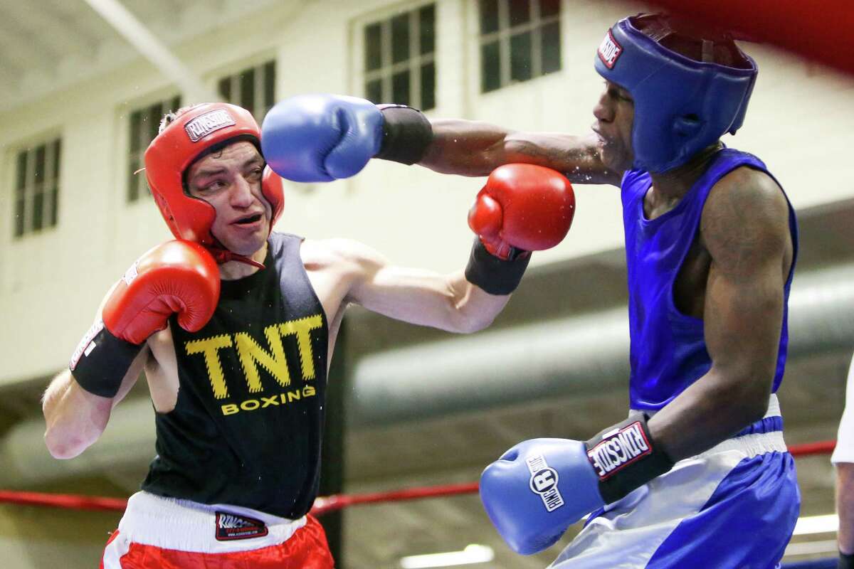 Kamryn Dungy (right) fighting with the USAF, trades punches with Bryan Vasquez, fighing unattached, during opening night of the 2015 San Antonio Regional Golden Gloves boxing tournament at Woodlawn Gym on Monday, Feb. 16, 2015. MARVIN PFEIFFER/ mpfeiffer@express-news.net