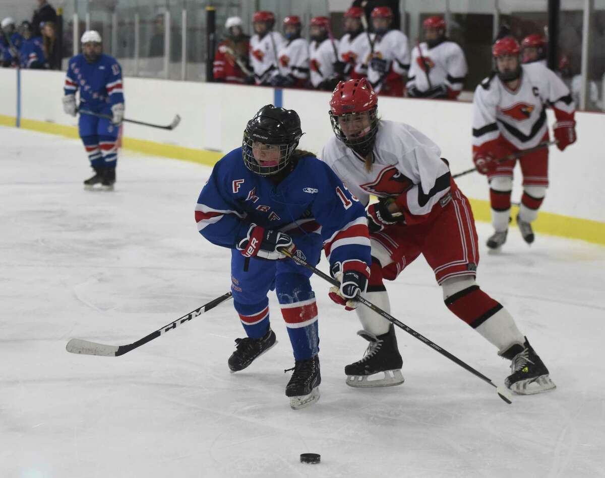Fairfield's Mary Edmonds skates past Greenwich's Claire Eschricht during girls' hockey action Monday. Edmonds scored five goals, giving her 45 for the season, as the Mustangs defeated the Cardinals 7-4 to finish the season with a 9-8 record.