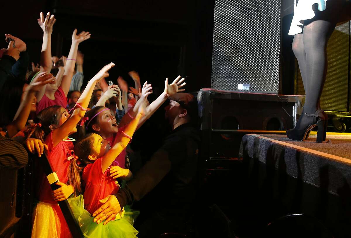 A group of young fans cheer as Meghan Trainor (legs at right) performs at The Fillmore on Monday, February 16, 2015 in San Francisco, Calif.