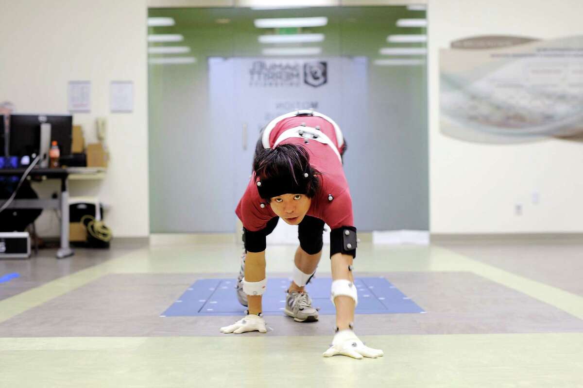 Kenichi Ito, who calls himself the monkey man, wears reflective markers to record his motion as he runs on all fours at Samuel Merritt University in Oakland.