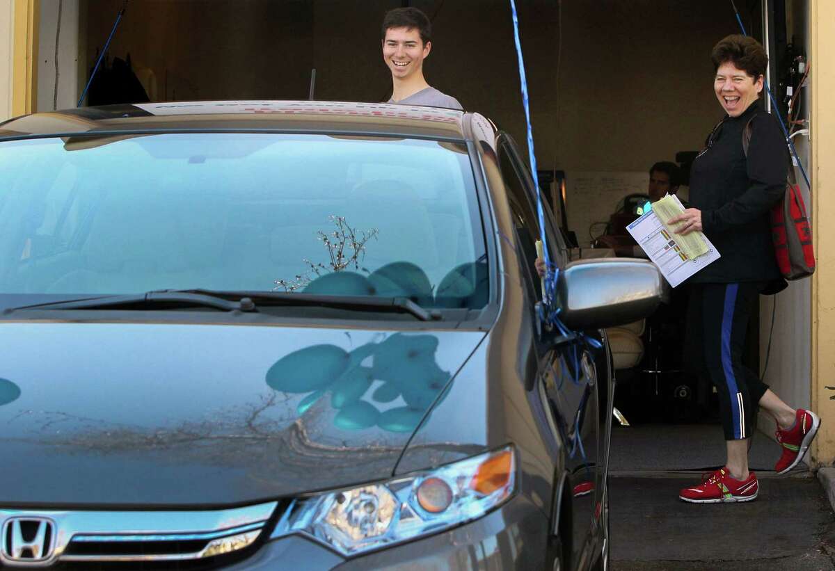 Miles Bennett-Smith, left, and his mother Elena Bennett are all smiles after purchasing a 2013 Honda Insight from Carlypso, a new online service for used-car buyers, Saturday, Feb. 14, 2015, in San Carlos, Calif.
