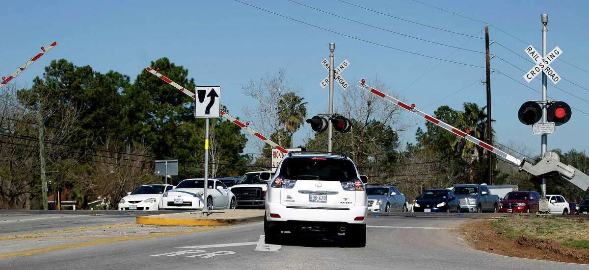 Crossing arms rise after a train passes and drivers had to wait to cross over the railroad tracks at the intersection of FM 359 and U.S. 90A on Feb. 9 near Richmond.