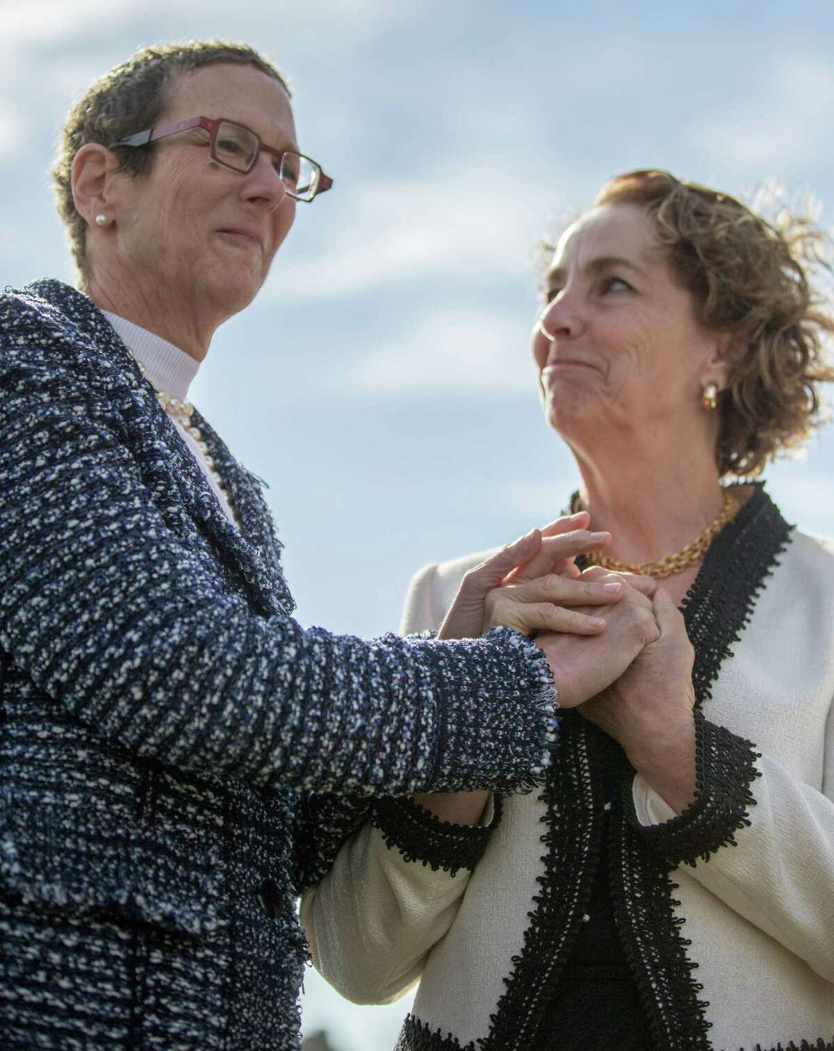 Suzanne Bryant, right, and Sarah Goodfriend hold hands as they wait for the wedding ceremony to begin with Rabbi Kerry Baker outside of the Travis County Clerk's office in Austin, Texas on Thursday morning. (AP Photo/Austin American-Statesman, Ricardo B. Brazziell)