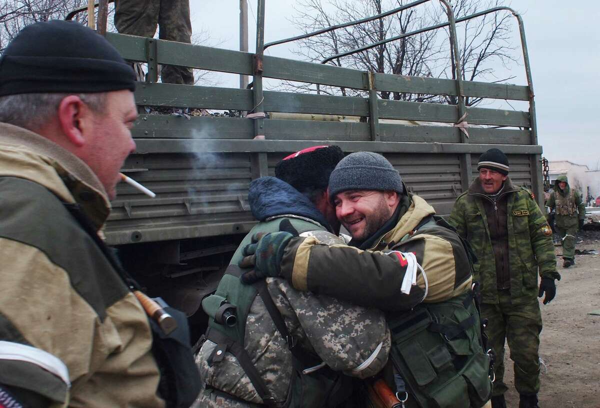 A pro-Russia rebel cossack, second left, hugs another rebel in Debaltseve, eastern Ukraine, Thursday, Feb. 19, 2015. After weeks of relentless fighting, the embattled Ukrainian rail hub of Debaltseve fell Wednesday to Russia-backed separatists, who hoisted a flag in triumph over the town. The Ukrainian president confirmed that he had ordered troops to pull out and the rebels reported taking hundreds of soldiers captive. (AP Photo/ Peter Leonard)