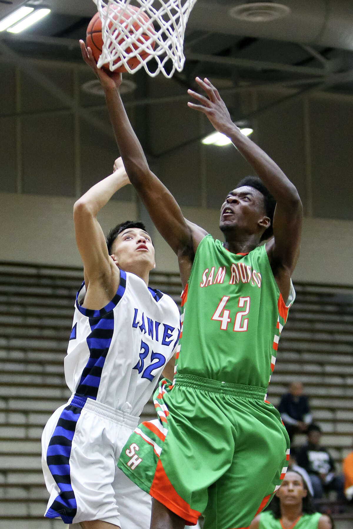 Sam Houston's Devin Allen (42) goes to the basket past Lanier's Luis Martinez (32) during the first half of their game at the Alamo Convocation Center on Friday, Feb. 13, 2015. Allen led all scorers with 20 points to help Sam Houston beat Lanier 72-60, handing the Voks their first district 28-5A loss. MARVIN PFEIFFER/ mpfeiffer@express-news.net
