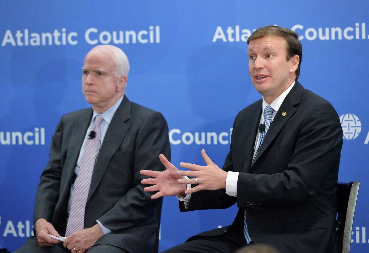 US Senator Christopher Murphy (R), D-CT, speaks as US Senator John McCain, R-AZ, watches during the Toward a Europe Whole and Free conference at the Atlantic Council on April 29, 2014 in Washington, DC.