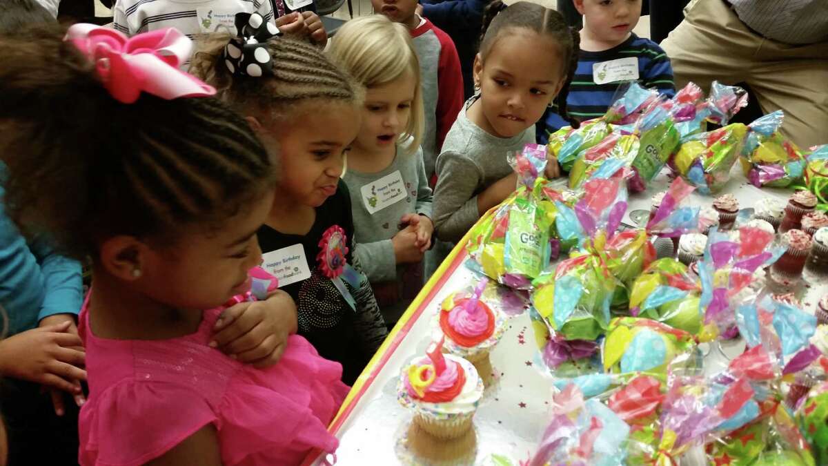Eden and Jasmine Bashir admire their cupcakes at the Houston Food Bank for the girls' joint birthday celebration.