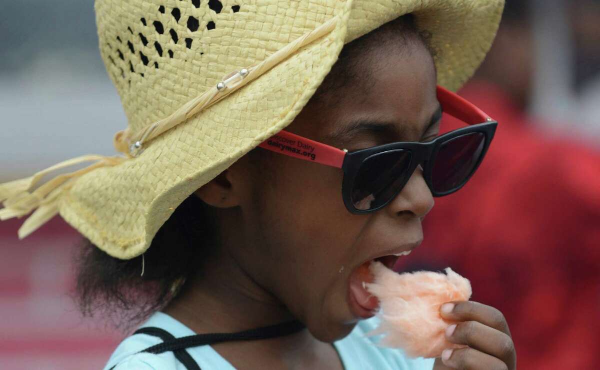 Vanessa Brown, 7, enjoys cotton candy on the grounds of the San Antonio Stock Show & Rodeo on Friday, Feb. 20, 2015.