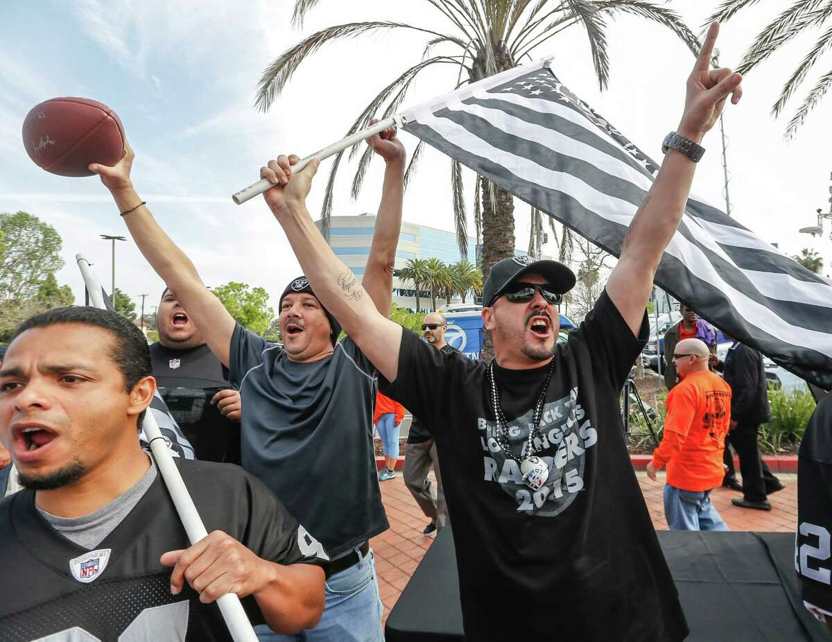 Raiders fan Sergio Gutierrez, right, joins football fans celebrating a proposed NFL football stadium by the owners of the San Diego Chargers and Oakland Raiders, during a news conference in Carson, Calif., on Friday, Feb. 20, 2015. The Oakland Raiders and San Diego Chargers owners are planning a shared stadium in the Los Angeles area if both teams fail to get new stadium deals in their current hometowns. The teams announced plans for the $1.7 billion stadium in a joint statement Thursday night, Feb. 19, 2015. The new NFL football stadium would be built on a 168-acre site at the southwest quadrant of the intersection of the 405 Freeway and Del Amo Blvd. (AP Photo/Damian Dovarganes)