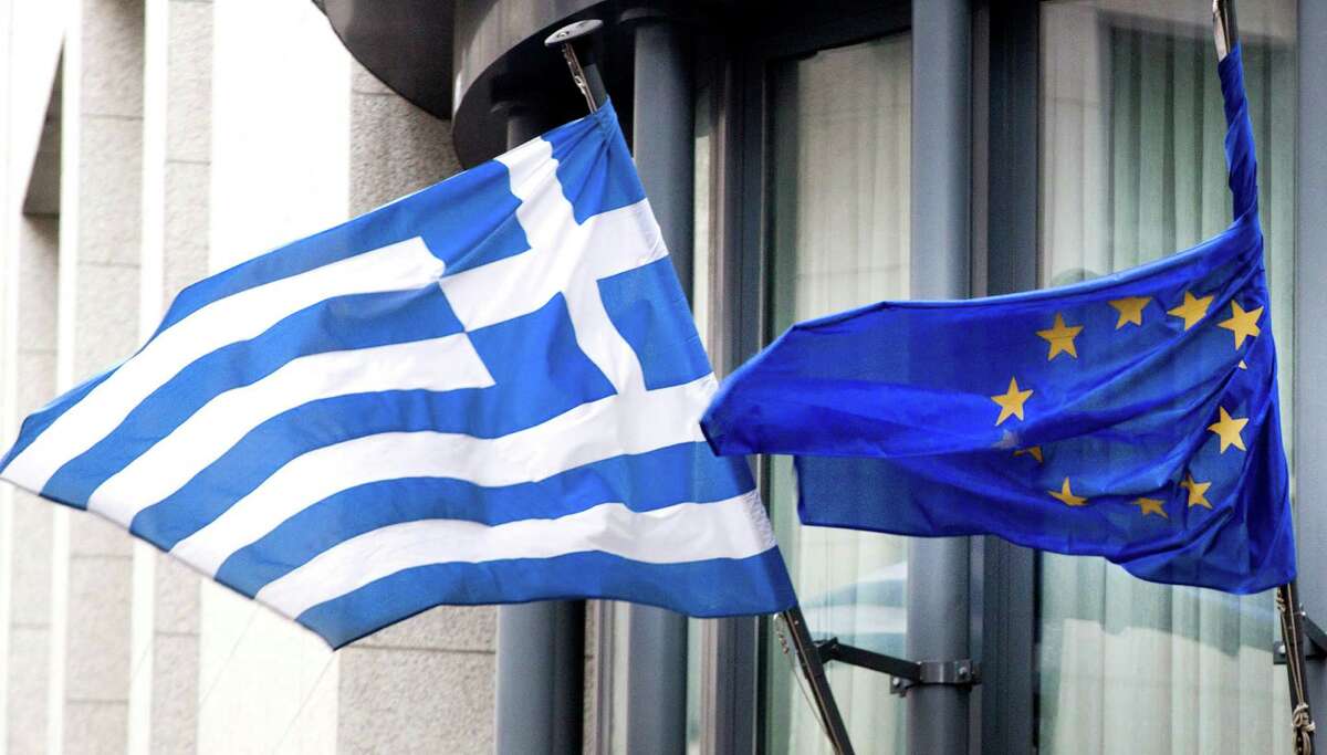 The Greek flag and the European Union flag fly at the Greek Embassy in Brussels. An agreement was reached with the Greek government.﻿