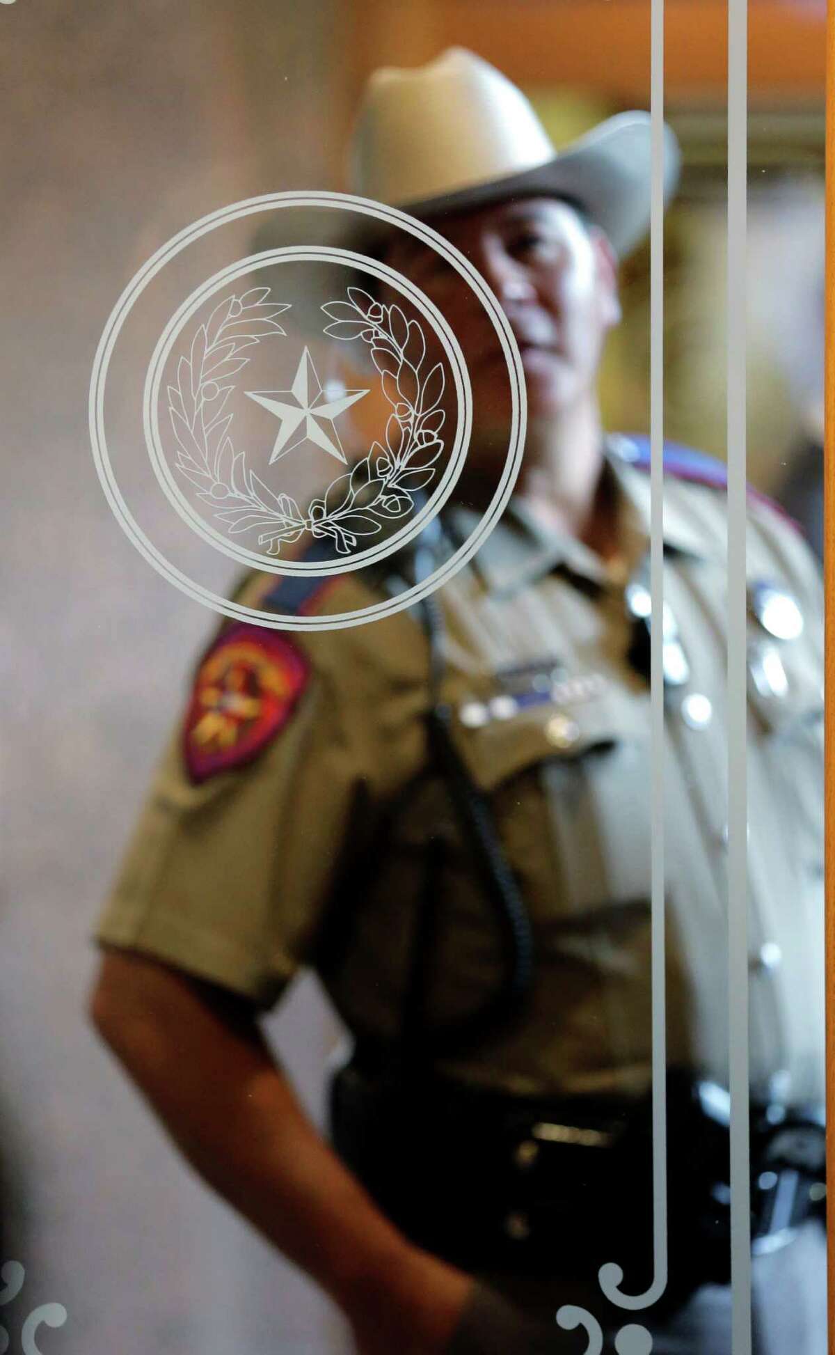 A Texas state trooper stands outside of a hearing where lawmakers discuss whether to legalize concealed handguns on college campuses and open carry everywhere else, Thursday, Feb. 12, 2015, in Austin, Texas. (AP Photo/Eric Gay)