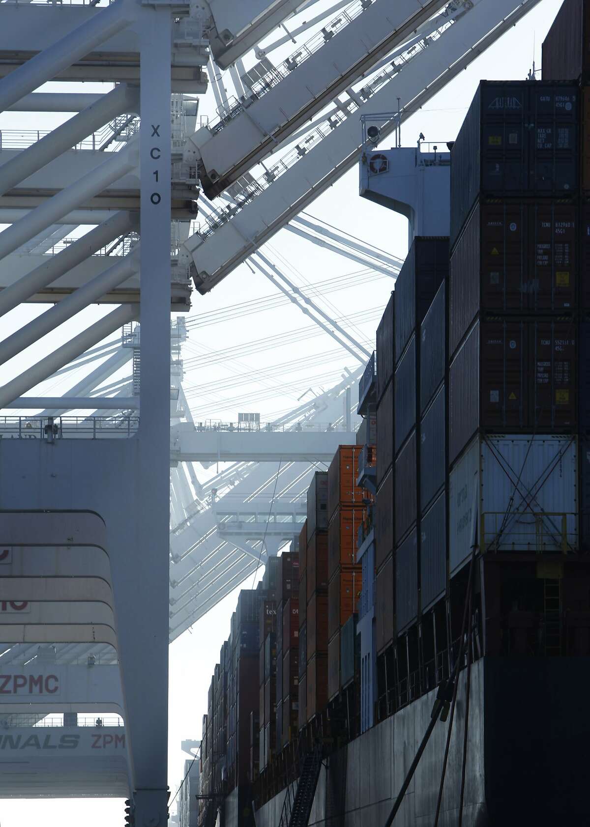 Containers from cargo ships are seen stacked under cranes in the Port of Oakland in Oakland, Calif. Saturday, February 21, 2015. The Port of Oakland recently reached a deal with longshoremen after labor disputes have created a backup of ships with cargo at the port.