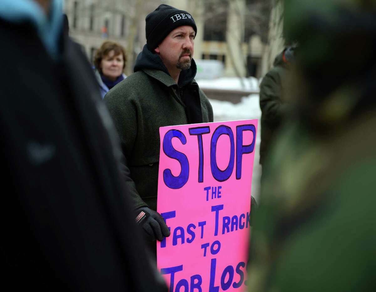 Mike D'Amico, of Shelton, an electrician and representative for The International Brotherhood of Electrical Workers (IBEW) protests the Trans-Pacific Partnership (TPP) "free trade" agreement Saturday, Feb. 21, 2015, during a demonstration on McLevy Green, across the street from Congressman Jim Himes' office.