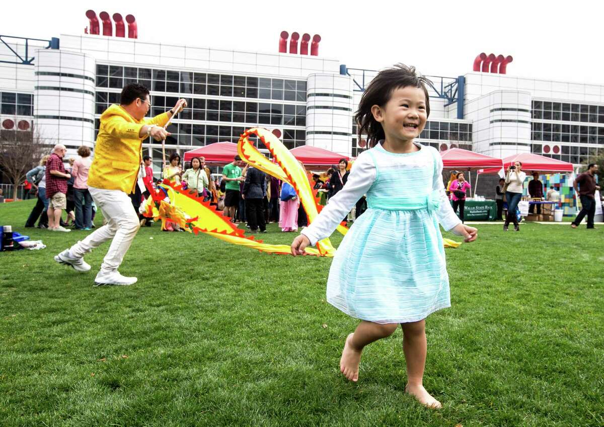 Cindy Lee runs in the grass during the 19th Annual Texas Lunar New Year Celebration at Discovery Green on Saturday, Feb. 21, 2015, in Houston.