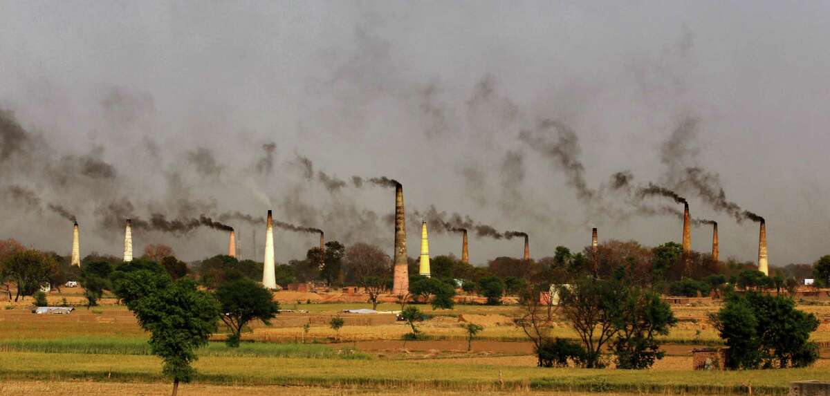 FILE - In this Sept. 23, 2014 file photo, smoke rises from brick kiln chimneys on the outskirts of New Delhi, India. Indiaâs filthy air is cutting 660 million lives short by about three years, while nearly all of the countryâs 1.2 billion citizens are breathing in harmful pollution levels, according to research published Saturday, Feb. 21, 2015. While New Delhi last year earned the dubious title of being the worldâs most polluted city, the problem extends nationwide, with 13 Indian cities now on the World Health Organizationâs list of the 20 most polluted. (AP Photo/Altaf Qadri, File)