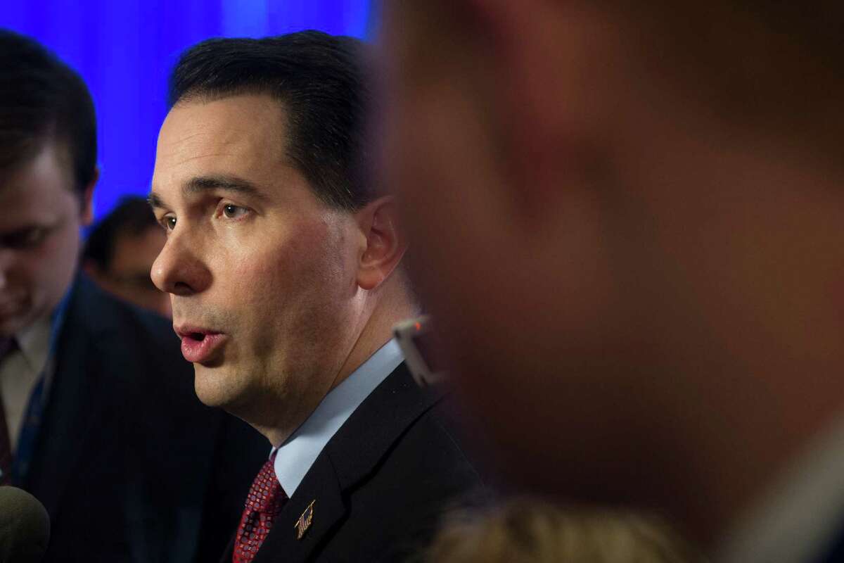 Wisconsin Gov. Scott Walker speaks with reporters at the conclusion of the opening session of the National Governors Association Winter Meeting in Washington, Saturday, Feb. 21, 2015. (AP Photo/Cliff Owen)