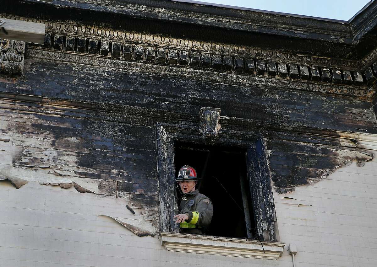 A fire fighter talked with others below as he stood on the top floor of the apartment building on 15th Street. A three alarm fire in the Castro district of San Francisco, Calif affected three buildings and left dozens without a home. On Sunday February 22, 2015, some work continued at the scene and the fire department responded to a smoke sighting.