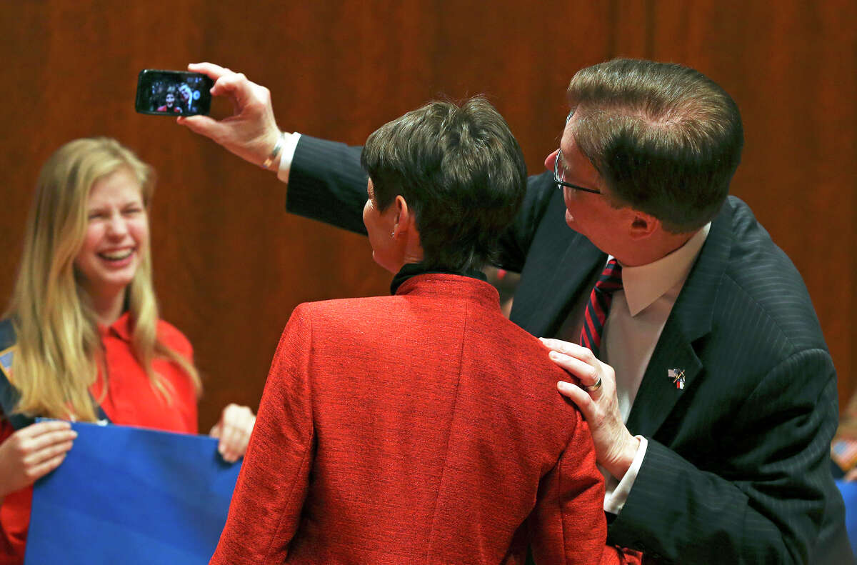 Lt. Gov. Dan Patrick takes another selfie, this time with Senator Donna Campbell as they meet on stage at the Texas Faith and Family Day rally in the Capitol Auditorium on February 24, 2015