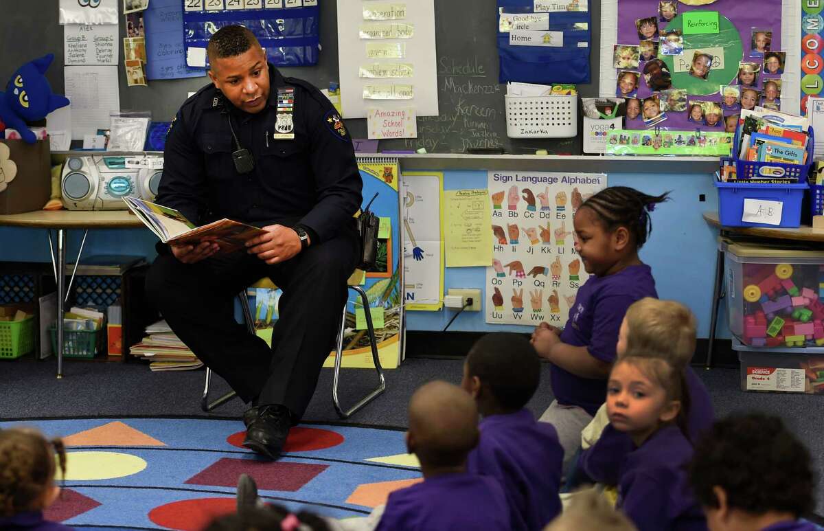 Troy Police officer Chris Johnson reads a poem by poet laureate Maya Angelou to students in Mrs. Ann Miller's kindergarten class during a Black History Month program event Tuesday morning, Feb. 24, 2015, at Public School 2 in Troy, N.Y. (Skip Dickstein/Times Union)