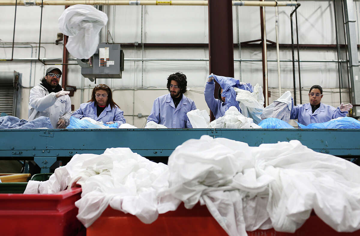 Workers divide medical facility linen Tuesday at Division Laundry & Cleaners at 6649 W. U.S. 90. Peter Garcia started the business in 1939 inside Fort Sam Houston. He would wash the soldiers' uniforms. Besides servicing area hospitals, the company also now works with hotels.