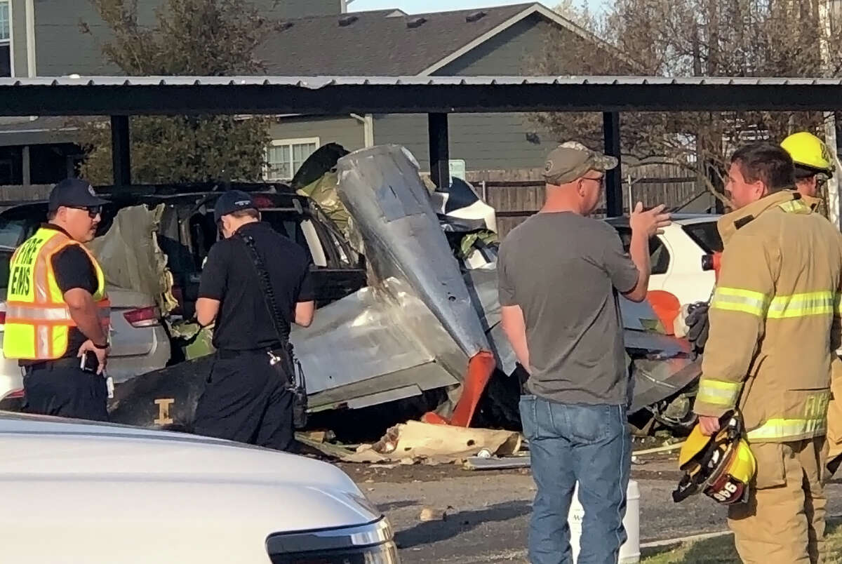 First responders work the scene of a plane crash Saturday afternoon in Fredericksburg, Texas. The P-51 Mustang crashed into the Terrace at Creek Street Apartments and early reports indicate two people were killed in the crash, both veterans.