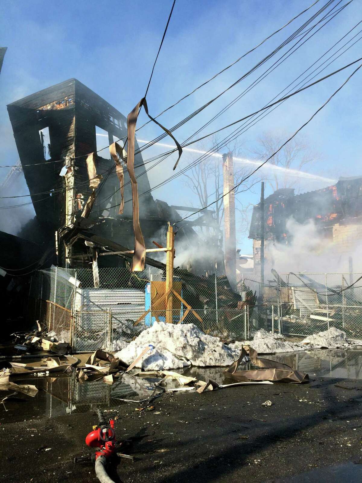 A raging fire engulfed four buildings on Hanover St. in Bridgeport's West Side shortly before 1 p.m. Friday Feb. 27, 2015. Two of the buildings were burned to the ground.