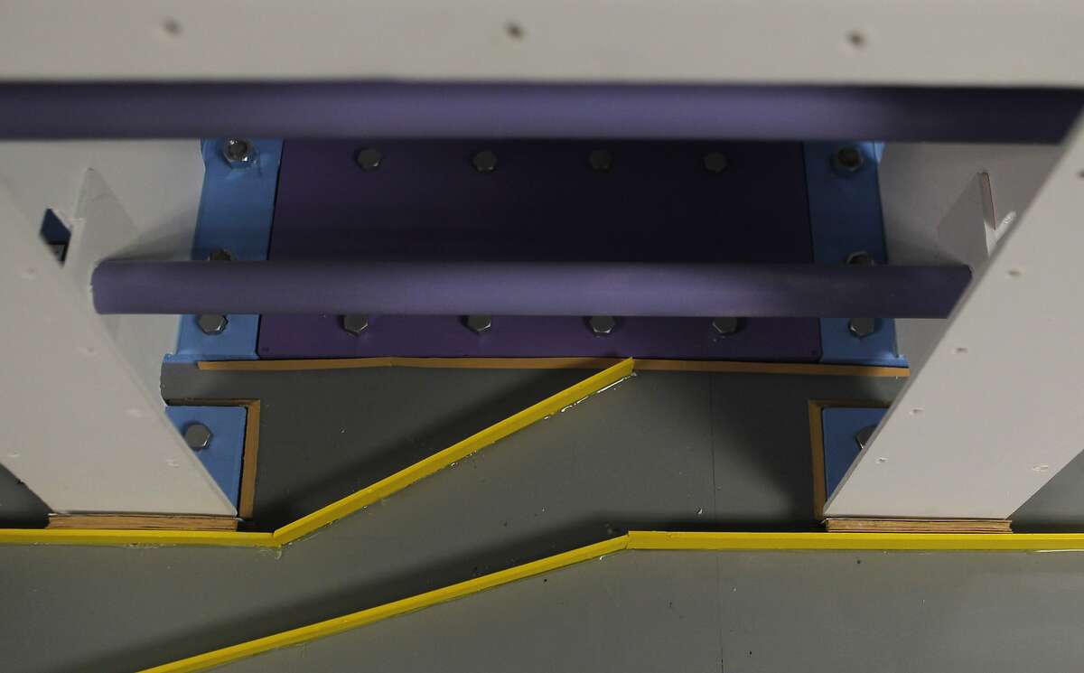 A model showing the design modification of the Bay Bridge's steel barrier sits on display at the CalTrans public information office in Oakland, Calif. Friday, February 27, 2015. The addition of a new plate and a change in the bridge railing will prevent leakage, forcing water to flow a new direction (indicated in yellow) out of the hollow barrier.