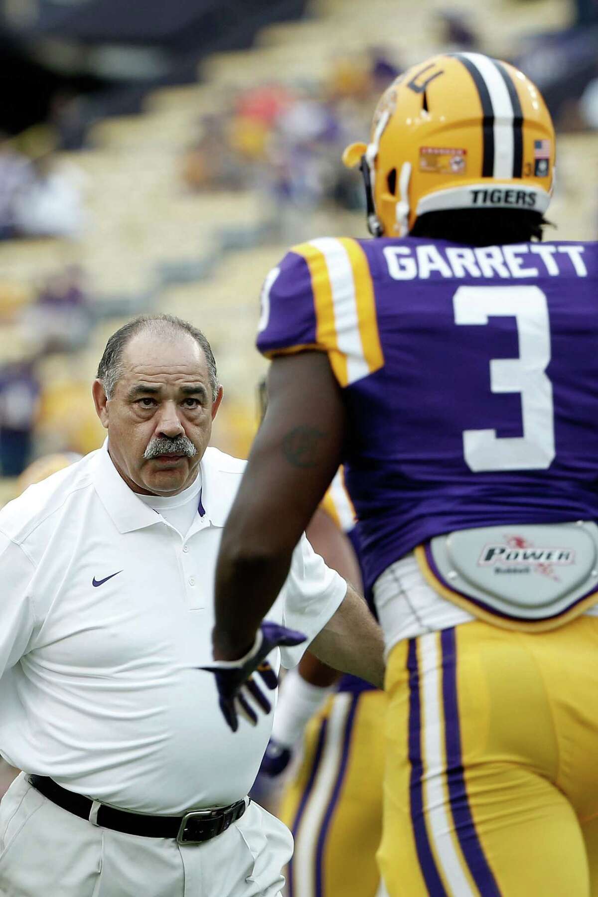 Defensive coordinator John Chavis of the LSU Tigers works with Clifton Garrett prior to a game against the Louisiana Monroe Warhawks at Tiger Stadium on September 13, 2014 in Baton Rouge, Louisiana. LSU won the game 31-0.